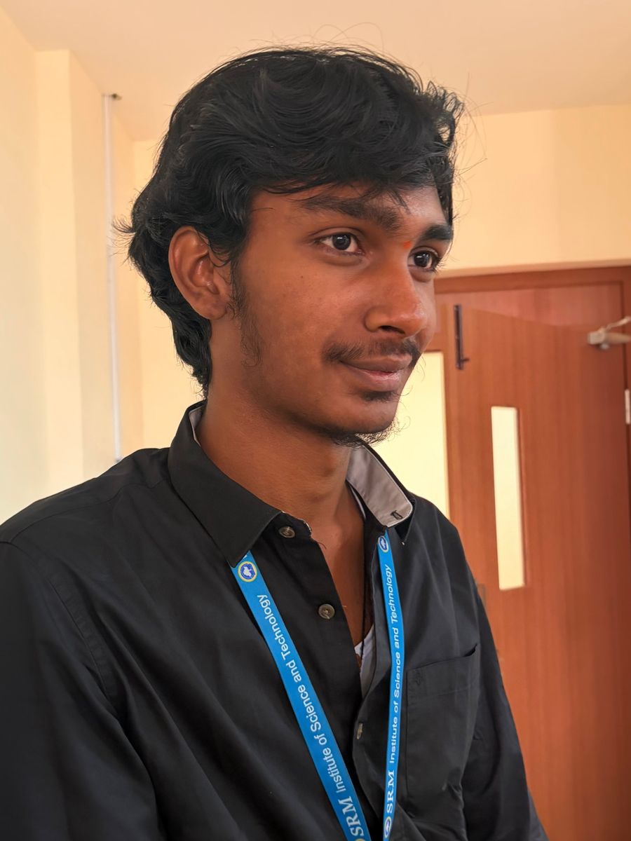 Nuthan smiling, wearing an SRM lanyard